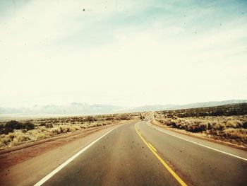 Empty road along countryside landscape