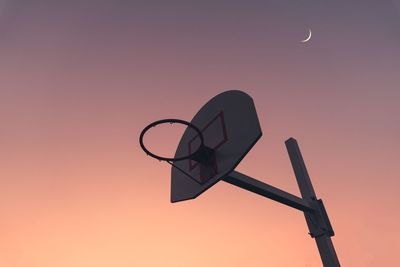 Low angle view of basketball hoop against sky during sunset