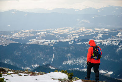 Rear view of hiker on mountain during winter