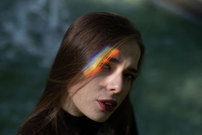 Close-up portrait of young woman with spectrum