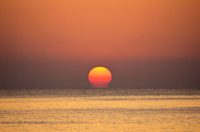 Scenic view of sea against orange sky