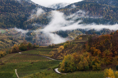 Autumn landscape in a mountain valley with arrow shaped cloud