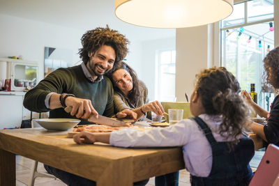 Happy family having lunch together on dining table at home