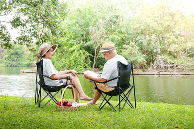 Senior couple sitting by lake at park