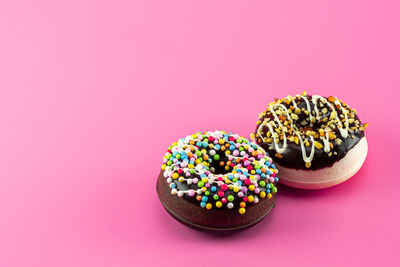 Multi colored candies against pink background