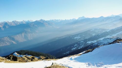 Scenic view of snowcapped mountains against clear blue sky