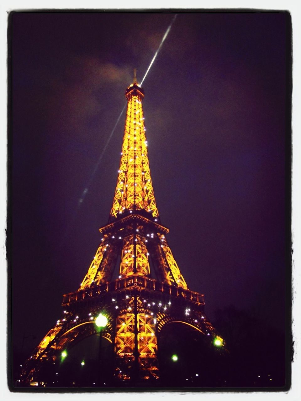 illuminated, transfer print, architecture, night, built structure, sky, low angle view, travel destinations, building exterior, famous place, city, capital cities, travel, auto post production filter, tourism, tower, international landmark, eiffel tower, outdoors, dusk