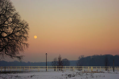 Scenic view of frozen lake against orange sky