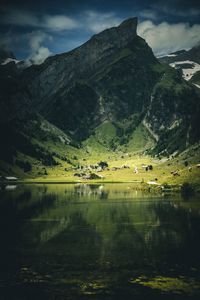 Scenic view of lake by mountain against sky