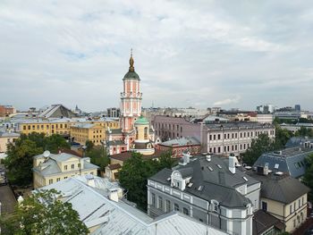 Buildings in city against cloudy sky