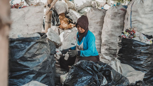 A female worker recycles plastic bottle waste at a plastic waste management site in malang city. 