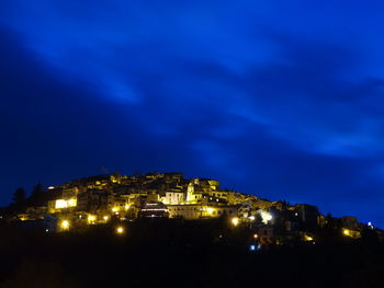 Low angle view of illuminated buildings against sky at night