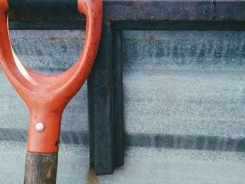 Close-up of orange work tool against wall