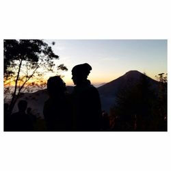 Silhouette couple against mountains during sunset