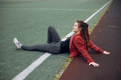 Low section of woman sitting on road