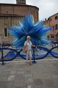 Portrait of woman standing against built structure