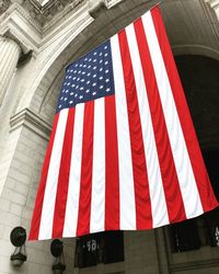 Low angle view of flag against building in city