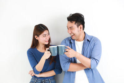 Young man and woman standing against white background