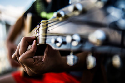 Midsection of man playing guitar