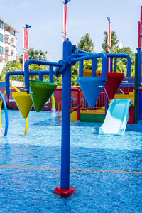 View of swimming pool in playground against blue sky