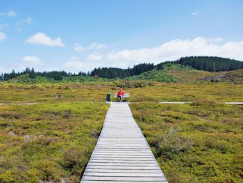 Rear view of people on land against sky
