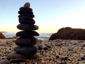 Stack of pebbles on beach against clear sky