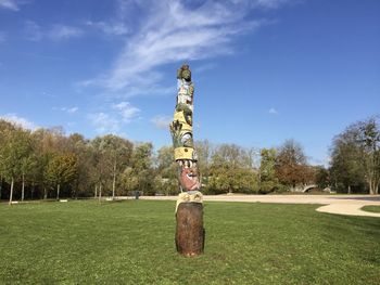 Trees on field in park against sky