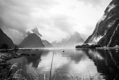 Scenic view of lake and mountains against sky, milford sound