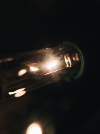 Close-up of illuminated lamp against black background