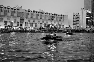 Canal amidst buildings in city against clear sky