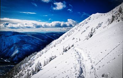 Scenic view of snowcapped mountains against blue sky