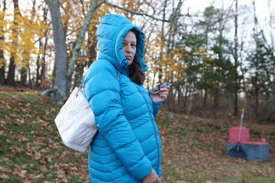 Portrait of young woman standing in forest