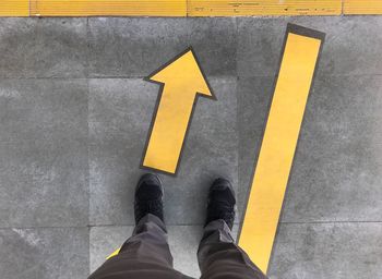 Low section of man standing on zebra crossing