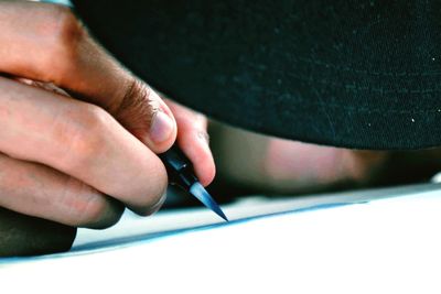 Close-up of man writing on paper