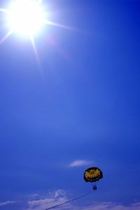 Low angle view of sun shining through clouds