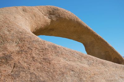 Low angle view of rocks against clear blue sky