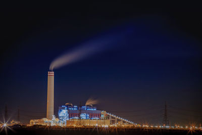Smoke emitting from factory against sky at night