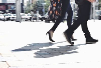 Low section of women walking on street