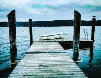 Wooden pier over lake against sky