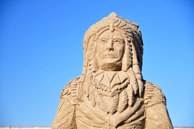 Low angle view of statue against clear blue sky