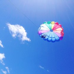 Low angle view of multi colored umbrella against blue sky