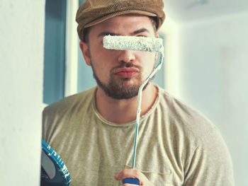 Portrait of man with paint roller