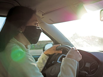 Midsection of man using mobile phone while sitting in car