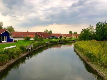 Scenic view of lake by buildings against sky