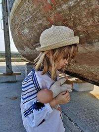 Side view of sad girl holding doll