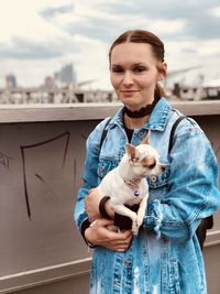 Portrait of smiling girl with a dog standing outdoors