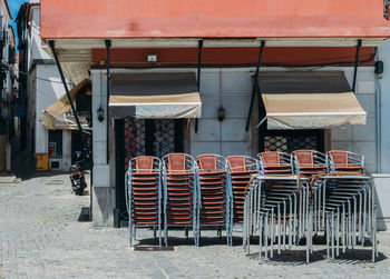 Empty chairs and tables in cafe against building