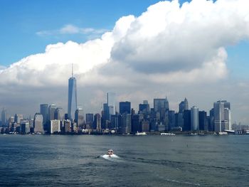 Scenic view of sea and cityscape against sky