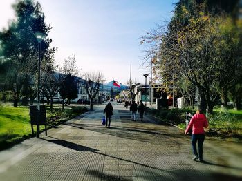 People walking on street against sky