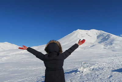 Low angle view of person on snowcapped mountain against sky